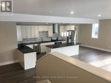 Ottawa multi-family for rent - A modern kitchen with a large island and stainless steel appliances.