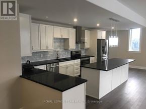 Ottawa multi-family for rent - A kitchen with black countertops and white cabinets.