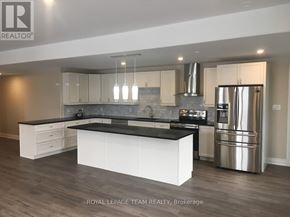 Ottawa multi-family for rent - A modern kitchen with a large island and stainless steel appliances.