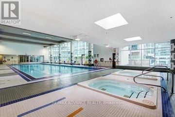Toronto (Waterfront Communities) condo for rent - A large indoor swimming pool with a hot tub in the middle.