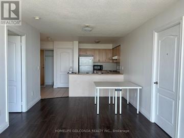 Toronto (Bendale) condo for rent - A white table is in the middle of a kitchen with wood floors.