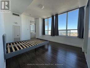 Toronto (Bendale) condo for rent - A bedroom with a large bed and a view of the city.