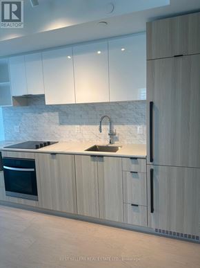 Toronto (Church-Yonge Corridor) condo for rent - A modern kitchen with white cabinets and a marble backsplash.