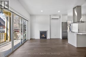 Toronto (The Beaches) apartment for rent - A spacious living room with a fireplace and a kitchen area.