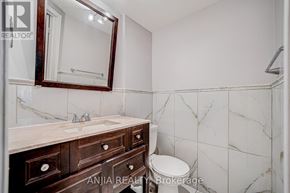 Markham (Cedarwood) townhouse for rent - A bathroom with a marble tile wall and a wooden vanity.