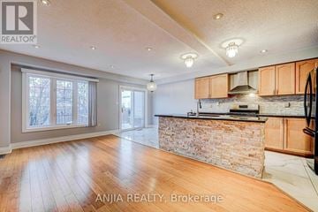 Markham (Cedarwood) townhouse for rent - A spacious kitchen with wooden cabinets and a stone backsplash.