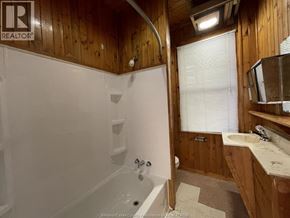Windsor apartment for rent - A bathroom with a wooden ceiling and a white bathtub.