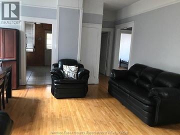 Windsor apartment for rent - A living room with a black leather couch and chair.