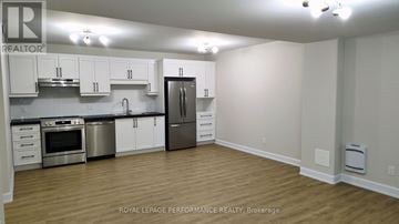 Russell duplex for rent - A kitchen with white cabinets and stainless steel appliances.