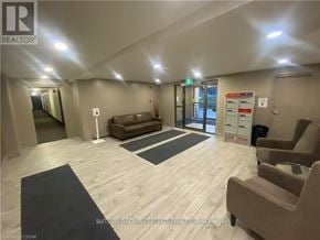 London South (South M) condo for rent - A waiting room with a couch, chairs, and a door.