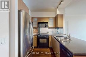 Toronto (Yonge-St. Clair) condo for rent - A kitchen with a refrigerator, microwave, oven, and sink.