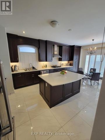 Brampton (Credit Valley) apartment for rent - A kitchen with dark brown cabinets and a white island.