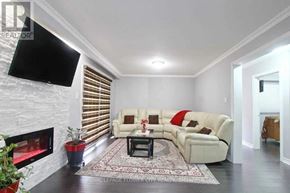 Toronto (Humber Summit) apartment for rent - A living room with a white couch, a fireplace, and a flat screen TV mounted on the wall.