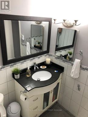Toronto (Humber Summit) apartment for rent - A bathroom with a sink, mirror, and toilet.