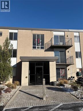 Windsor apartment for rent - A building with a black door and windows with red curtains.