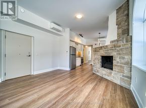 Oro-Medonte (Hawkestone) multi-family for rent - A living room with a stone fireplace and wood flooring.