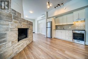 Oro-Medonte (Hawkestone) multi-family for rent - A stone fireplace in a modern kitchen with wooden floors.