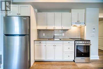 Oro-Medonte (Hawkestone) multi-family for rent - A kitchen with a stainless steel refrigerator and a stainless steel oven.