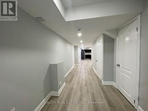Brampton (Northwest Brampton) apartment for rent - A long hallway with white walls and wood flooring.