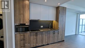 Kitchener condo for rent - A modern kitchen with wooden cabinets and a stainless steel countertop.