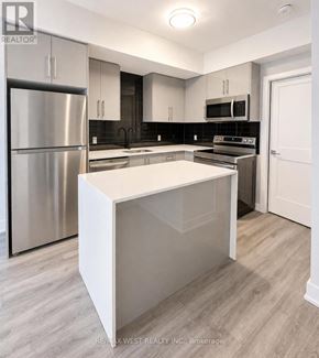 Niagara Falls (Arad/Fallsview) townhouse for rent - A modern kitchen with stainless steel appliances and a white island.