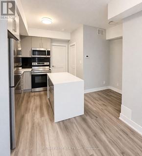 Niagara Falls (Arad/Fallsview) townhouse for rent - A kitchen with a refrigerator, oven, and microwave.