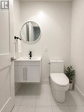 Niagara Falls (Arad/Fallsview) townhouse for rent - A white bathroom with a toilet, sink, and mirror.
