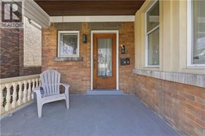 Hamilton apartment for rent - A wooden chair is on a porch with a brick wall.
