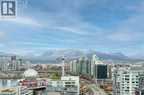 Vancouver apartment for rent - A cityscape with a large white dome structure in the foreground and mountains in the background.