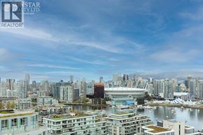 Vancouver apartment for rent - A cityscape with a large body of water in the foreground and a stadium in the background.