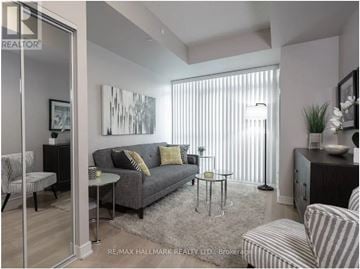 Toronto (Bay Street Corridor) condo for rent - A living room with a grey couch and a painting on the wall.