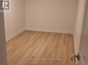 Toronto (Milliken) apartment for rent - A room with wooden flooring and white walls.