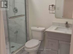 Toronto (Milliken) apartment for rent - A white toilet sits next to a sink in a bathroom.