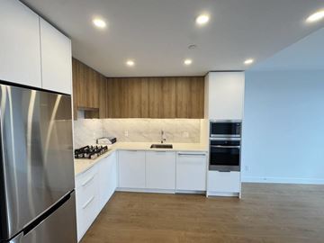 Surrey apartment for rent - A modern kitchen with wooden cabinets and stainless steel appliances.