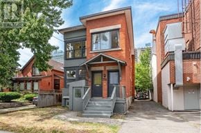 Ottawa triplex for rent - A red brick house with a grey front door and steps.
