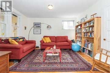 Ottawa triplex for rent - A living room with red couches and a rug.