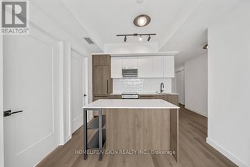 Toronto (Centennial Scarborough) condo for rent - A modern kitchen with white cabinets and a wooden island.