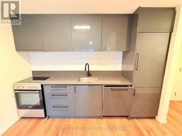 Toronto (North Riverdale) multi-family for rent - A kitchen with a stainless steel refrigerator, oven, and sink.