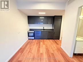 Toronto (North Riverdale) multi-family for rent - A kitchen with wooden floors and modern appliances.