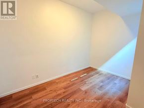 Toronto (North Riverdale) multi-family for rent - A room with wooden flooring and white walls.