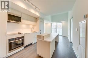 Burlington condo for rent - A modern kitchen with white cabinets and stainless steel appliances.