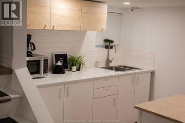 Windsor apartment for rent - A kitchen with white cabinets and a wooden counter.