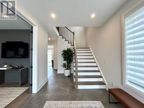 Fort Erie (Black Creek) apartment for rent - A living room with a staircase leading to the upper floor.