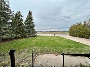 Niagara-On-The-Lake (Rural) apartment for rent - A view from a backyard with a green lawn and a fence.