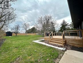 Niagara-On-The-Lake (Rural) apartment for rent - A backyard with a deck and a small tree.