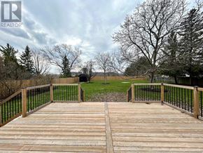 Niagara-On-The-Lake (Rural) apartment for rent - A wooden deck with a metal railing overlooks a grassy area.