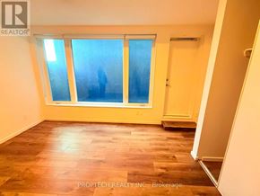 Toronto (North Riverdale) multi-family for rent - A room with a window and wooden flooring.