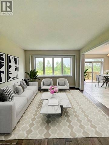 Welland apartment for rent - A living room with a white couch and a coffee table with a vase of flowers on it.