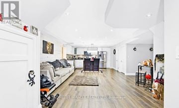Bradford West Gwillimbury (Bradford) apartment for rent - A well-lit, spacious living room with a grey sofa and a wooden floor.