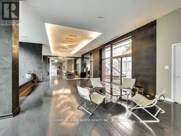 Toronto (Bay Street Corridor) condo for rent - A spacious living room with a long row of chairs facing a large window.